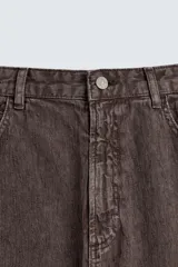 Pantalón de corte baggy fit confeccionado en tejido de algodón con textura y efecto lavado. Presenta diseño de cinco bolsillos, cierre frontal con cremallera y botón.