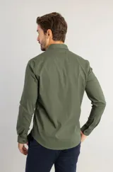 Camisa de manga larga en color verde militar, confeccionada en tejido de tricolina con elastano. Presenta un diseño liso, cuello clásico y cierre frontal con botones a tono. Incluye un pequeño detalle bordado en el pecho.