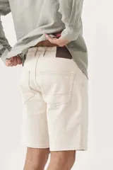 Bermuda de gabardina color crudo, corte recto y largo a la rodilla.