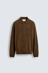 Sobrecamisa de punto con mezcla de lana y fibra de alpaca, color marrón. Presenta cuello solapa, cierre frontal con botones, manga larga y bolsillo plastrón en el pecho. Acabados en rib en puños y ruedo.