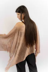 Poncho de tejido abierto color cobre con acabado brillante, decorado con pequeñas piedras incrustadas y flecos en los bordes.