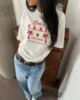 Remera oversize de color beige con estampa frontal en marrón, mangas cortas y cuello redondo.