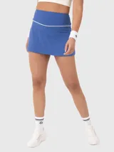Falda deportiva azul con ribete blanco en la cintura, diseñada con calza interior incorporada que incluye bolsillo lateral.