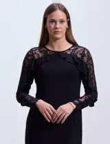 Vestido negro de seda fría con hombros y mangas largas de encaje con brillos y aplique fruncido.