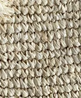 Sobre de rafia color marrón con cierre superior y borla decorativa.