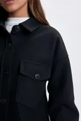 Sobrecamisa de paño en color negro, con cuello clásico, cierre frontal de botones y bolsillos frontales con solapa.
