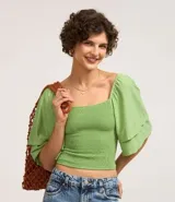 Blusa corta color verde claro con escote cuadrado y mangas cortas godê. Posee cuerpo en lastex, proporcionando un toque texturizado.