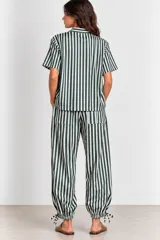 Blusa de algodón a rayas verde oscuro y blanco, con mangas cortas, cuello mao y detalle de botones tipo alamar en el frente. Presenta aberturas laterales en el ruedo.