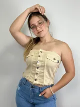 Top strapless color beige con botones plateados al frente y dos bolsillos pequeños.
