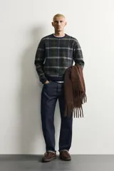 Pantalón de jean corte slim fit con efecto lavado, tiro medio, cinco bolsillos y cierre frontal con cremallera y botón.