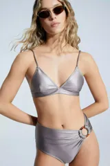 Corpiño de bikini plateado, con corte triangular, elástico inferior de 2 cm, breteles regulables y cierre trasero con gancho. Incluye espacio para almohadillas de relleno.