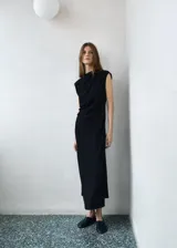Vestido midi sin mangas de color negro, con cuello redondo drapeado, tirantes anchos y fruncido lateral.