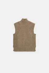 Chaleco de punto confeccionado en mezcla de lana, con cuello subido y diseño sin mangas. Presenta un tejido de punto acanalado en el cuello, sisas y ruedo, con un corte clásico y versátil.