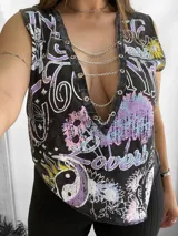 Remera negra sin mangas con cuello en V profundo adornado con cadenas plateadas. Estampado con motivos florales, tipografías y símbolos en tonos pastel.