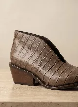 Botín de cuero vacuno con textura de reptil, diseño de corte bajo con abertura lateral en forma de V y taco cuadrado de madera.