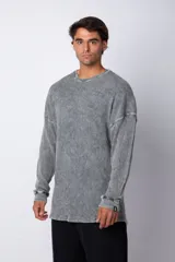 Buzo de corte oversize confeccionado en tela waffle de algodón con proceso de teñido acid wash. Presenta cuello redondo con detalle de costura en X y mangas largas con puños acanalados.