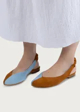 Ballerinas destalonadas de gamuza color camel, con suela plana, puntera redondeada y tira elástica fruncida en el talón. Interior de cuero en color celeste.