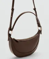 Bolso tipo hobo de tamaño pequeño, color marrón, con diseño ovalado tipo medialuna, asa corta y herrajes metálicos dorados. Cuenta con cierre de cremallera superior y textura granulada.
