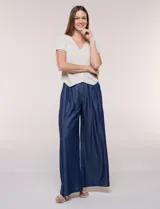 Cardigan corto de tejido de punto fino con hilo brillante de lurex y destellos metalizados. Presenta escote en V pronunciado, mangas cortas, cierre frontal con botones a tono y ruedo con terminación en pico en el frente.