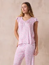 Conjunto de pijama marca René Rofé, compuesto por una remera de escote en V con botones y un pantalón capri con cintura elastizada, ambos en tejido soft estampado con motivos florales en tonos celeste y blanco.