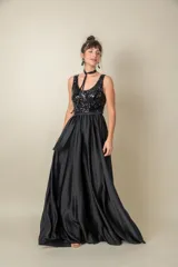 Vestido largo rojo con cuerpo de lentejuelas y falda de satén con caída fluida. Presenta escote redondo, sin mangas y un lazo en la cintura.
