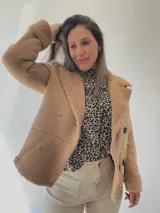 Chaqueta color beige con forro interno tipo corderito, doble botonadura y cuello solapa.