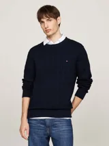 Sweater Tommy Hilfiger de punto trenzado color azul marino, con cuello redondo y logo bordado en el pecho.