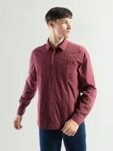 Camisa de manga larga color gris oscuro, confeccionada en algodón, con cuello clásico, cierre frontal con botones, bolsillo de parche en el pecho y corte clásico.