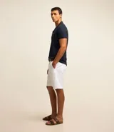 Bermuda de sarga color blanco, de corte recto y diseño básico con bolsillos laterales y traseros.