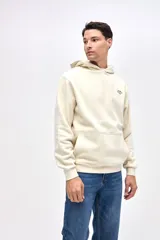Buzo tipo canguro de felpa con friza, color beige, con capucha, bolsillos laterales y puños elásticos. Presenta arte de marca estampado en el pecho y en la espalda.