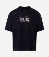 Remera de corte boxy en color negro, con cuello redondo y mangas cortas. Presenta un estampado gráfico en la espalda que muestra a los personajes Joker y Harley Quinn con la frase 'Mad Love'.