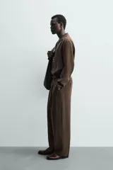 Camisa de manga larga color marrón oscuro, con cuello solapa y abertura frontal, confeccionada en tejido fluido con mezcla de modal. Presenta un calce relajado y aberturas laterales en el bajo.