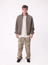 Campera Rusty de corte clásico, color negro, con cierre frontal completo, cuello alto y puños elásticos. Presenta un diseño minimalista con el logo de la marca bordado en el pecho.