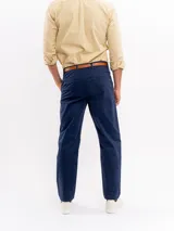 Pantalón chino de corte regular y tiro medio, color azul marino, con cierre de botón y cremallera, bolsillos laterales y traseros, y terminación recta.