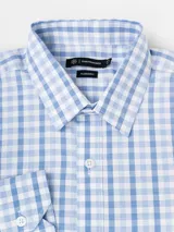 Camisa de manga larga marca Cuatroases, con estampado de cuadros vichy en tonos azul y blanco. Presenta cuello clásico, cierre frontal con botones blancos y puños abotonados.