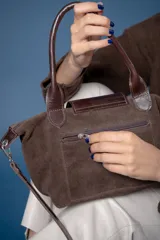 Cartera pequeña de mano tipo tote, confeccionada en gamuza color azul, con solapa y asas en cuero sintético con textura de reptil. Incluye cierre superior y correa larga ajustable y extraíble.