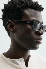 Camiseta de algodón color beige claro, de corte relajado (relaxed fit) con cuello redondo y manga corta. Presenta una textura sutil en el tejido.