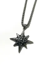 Collar de acero plateado con cadena de eslabones tipo box y un dije grande en forma de estrella de ocho puntas con detalles grabados y cruz central.