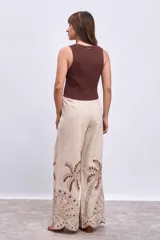 Chaleco tejido de punto color blanco, sin mangas, con escote en V y cierre frontal con botones dorados.