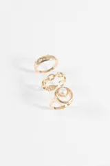Set de tres anillos plateados de diseño variado: uno con perla central, uno tipo cadena de eslabones y uno liso con pequeñas incrustaciones de cristales.