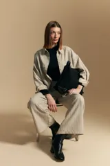 Polera de manga larga color marrón claro, con cuello alto y costura vertical decorativa en el frente.