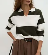 Suéter de punto con diseño de rayas horizontales anchas en color verde oscuro y blanco. Presenta cuello tipo polo con escote en V, mangas largas con puños ajustados y un corte regular.