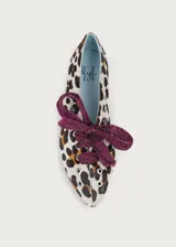 Bailarina de cuero con estampado animal print, decorada con tachuelas plateadas y un lazo desmontable de tela metalizada en color fucsia.