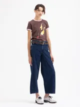 Remera de algodón pima orgánico color marrón, con cuello redondo y bordes de mangas en color rosa. Presenta un estampado frontal de cerezas con llamas.