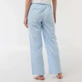 Pantalón de pijama de corte recto y holgado, confeccionado en popelina de algodón con estampado de rayas verticales celestes y blancas, y pequeños detalles decorativos. Cuenta con cintura elástica para mayor comodidad.