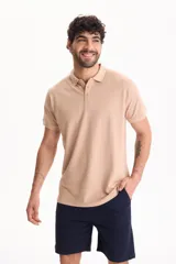 Chomba de piqué color blanco, con cuello polo y cierre frontal con tres botones.