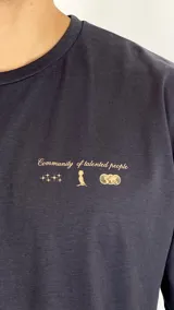 Remera de algodón color gris oscuro con cuello redondo, mangas cortas y estampa pequeña en el pecho con texto y símbolos.