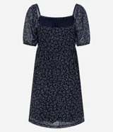 Vestido corto evasê de tule ligero color azul marino con estampado floral liberty fullprint en blanco. Posee escote recto, mangas cortas abullonadas y canesú fruncido en el busto.