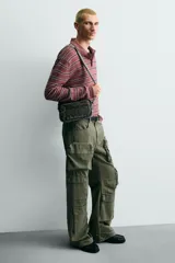 Bandolera de tejido denim con efecto lavado, cuenta con compartimento principal con cierre de cremallera, bolsillo interior con cierre y asa de hombro ajustable.