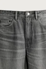 Jeans de denim de algodón en color azul con efecto desgastado, tiro medio y corte recto de ajuste holgado (loose fit). Cuenta con diseño clásico de cinco bolsillos y cierre frontal con cremallera y botón.